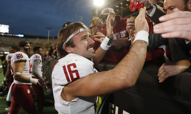 Washington State quarterback Gardner Minshew is congratulated by fans as he leaves the field after ...