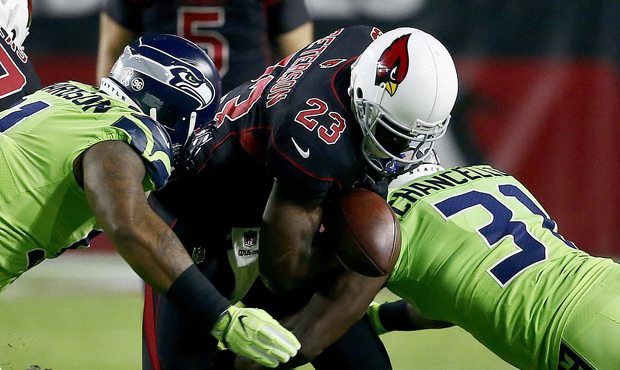 Arizona Cardinals running back Adrian Peterson (23) fumbles the football as Seattle Seahawks strong...