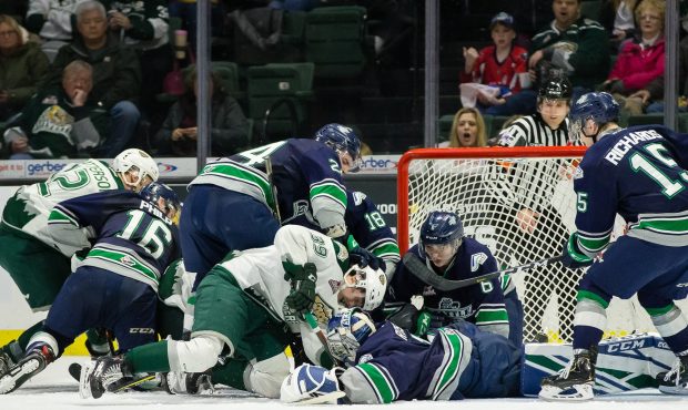 Seattle goalie Roddy Ross somehow finds the puck under a mass of bodies during the Thunderbirds win...
