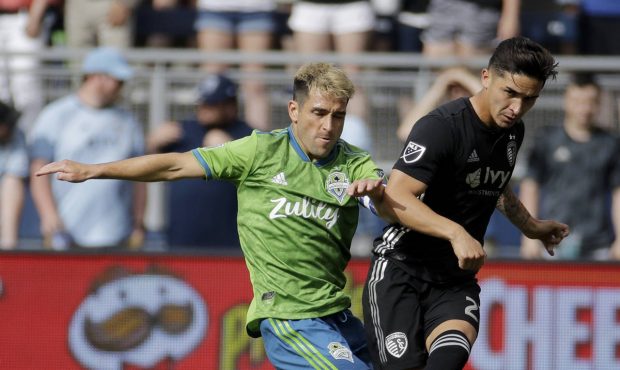Seattle Sounders midfielder Nicolas Lodeiro, left, and Sporting Kansas City midfielder Felipe Gutie...