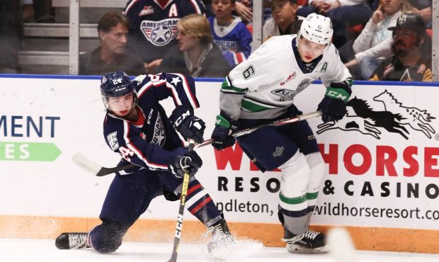 Tyrel Bauer fights for the puck with Tri-City's Edge Lambert Friday night in Kennewick. (Doug Love/...