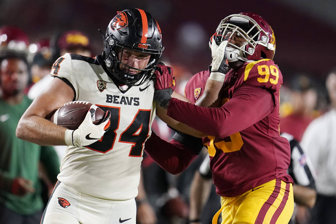 Oregon State tight end Teagan Quitoriano (84) stiff-arms Southern California linebacker Drake Jacks...