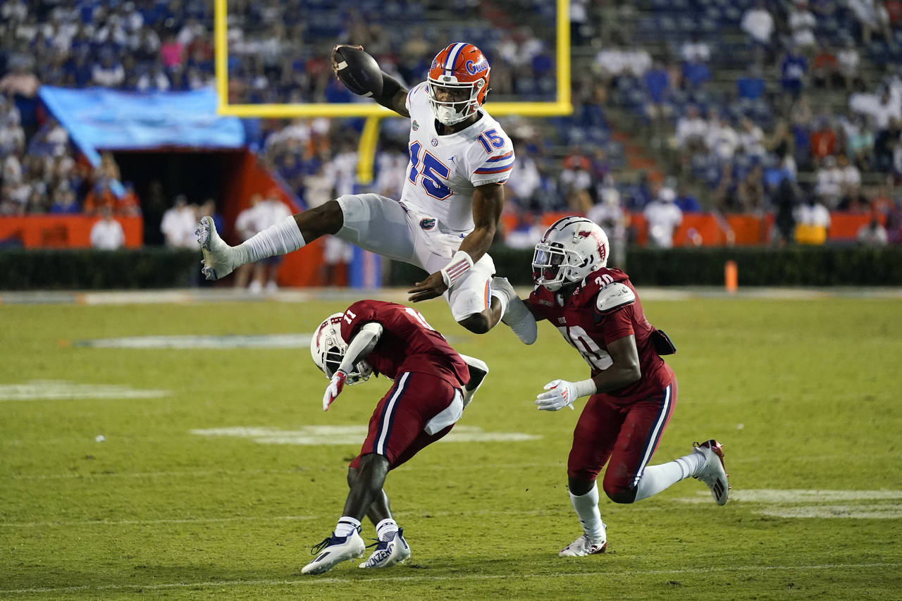 Florida quarterback Anthony Richardson (15) hurdles Florida Atlantic defensive back Justin McKithen...
