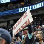 
              Seattle Kraken fans watches as the hockey team takes to the ice to warm up Saturday, Oct. 23, 2021, in Seattle, for the NHL hockey expansion team's home-opener against the Vancouver Canucks. (AP Photo/Elaine Thompson)
            