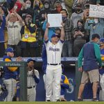 
              Seattle Mariners third baseman Kyle Seager holds up third base after it was given to him when he was subbed out of a baseball game against the Los Angeles Angels during the ninth inning, Sunday, Oct. 3, 2021, in Seattle. (AP Photo/Ted S. Warren)
            