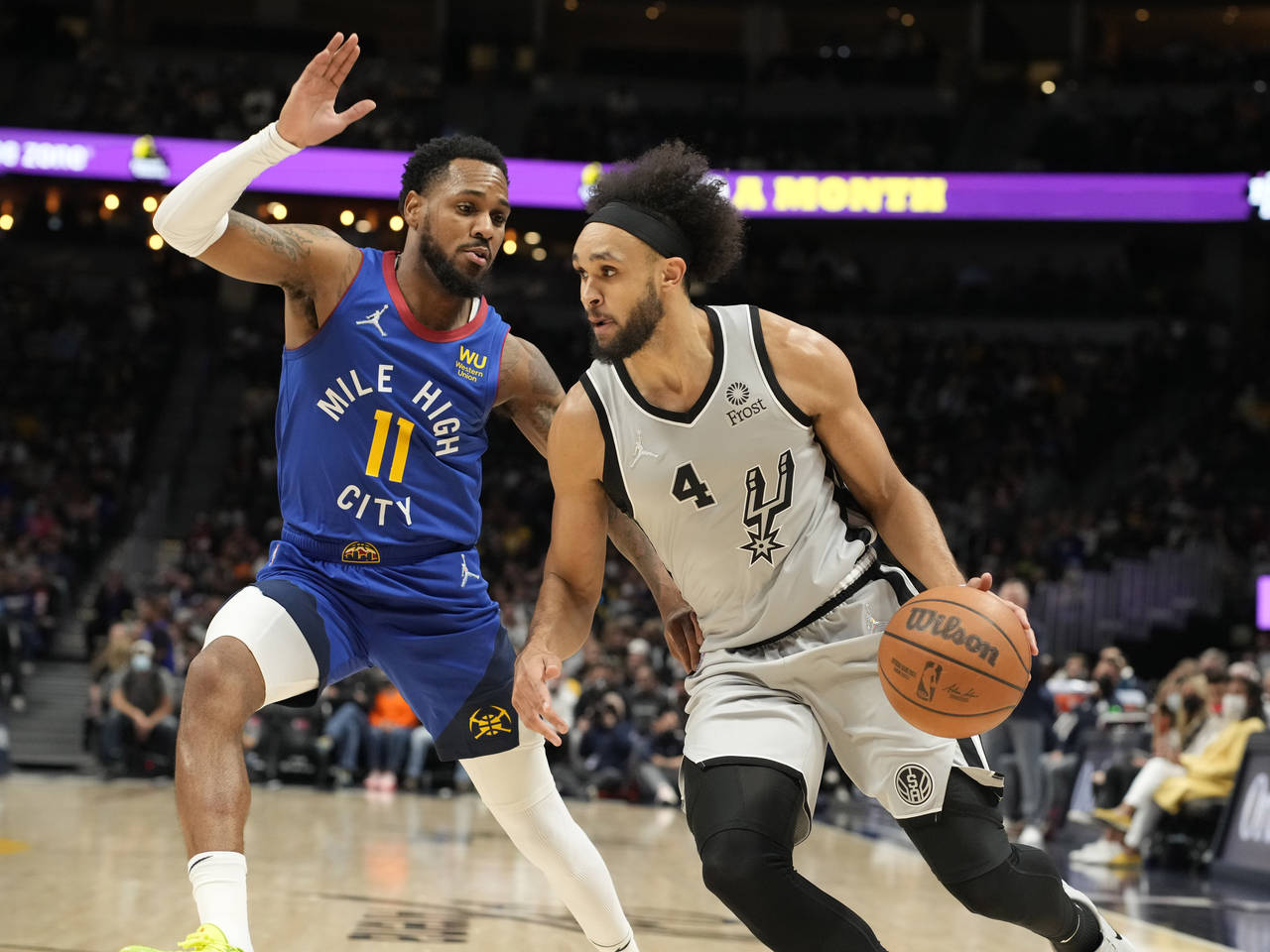 San Antonio Spurs guard Derrick White, right, is defended by Denver Nuggets guard Monte Morris duri...