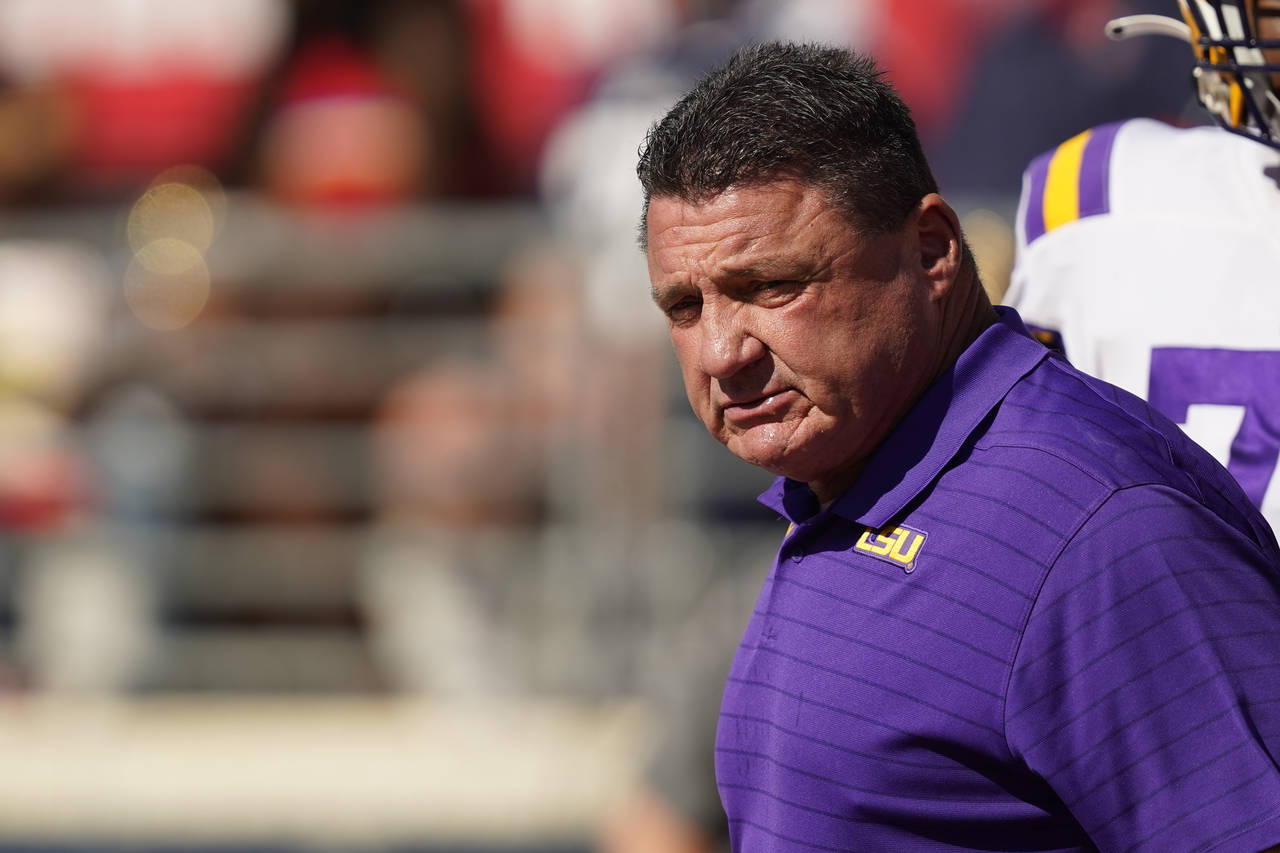 LSU head coach Ed Orgeron stares toward the sideline as his team goes through warmup drills prior t...