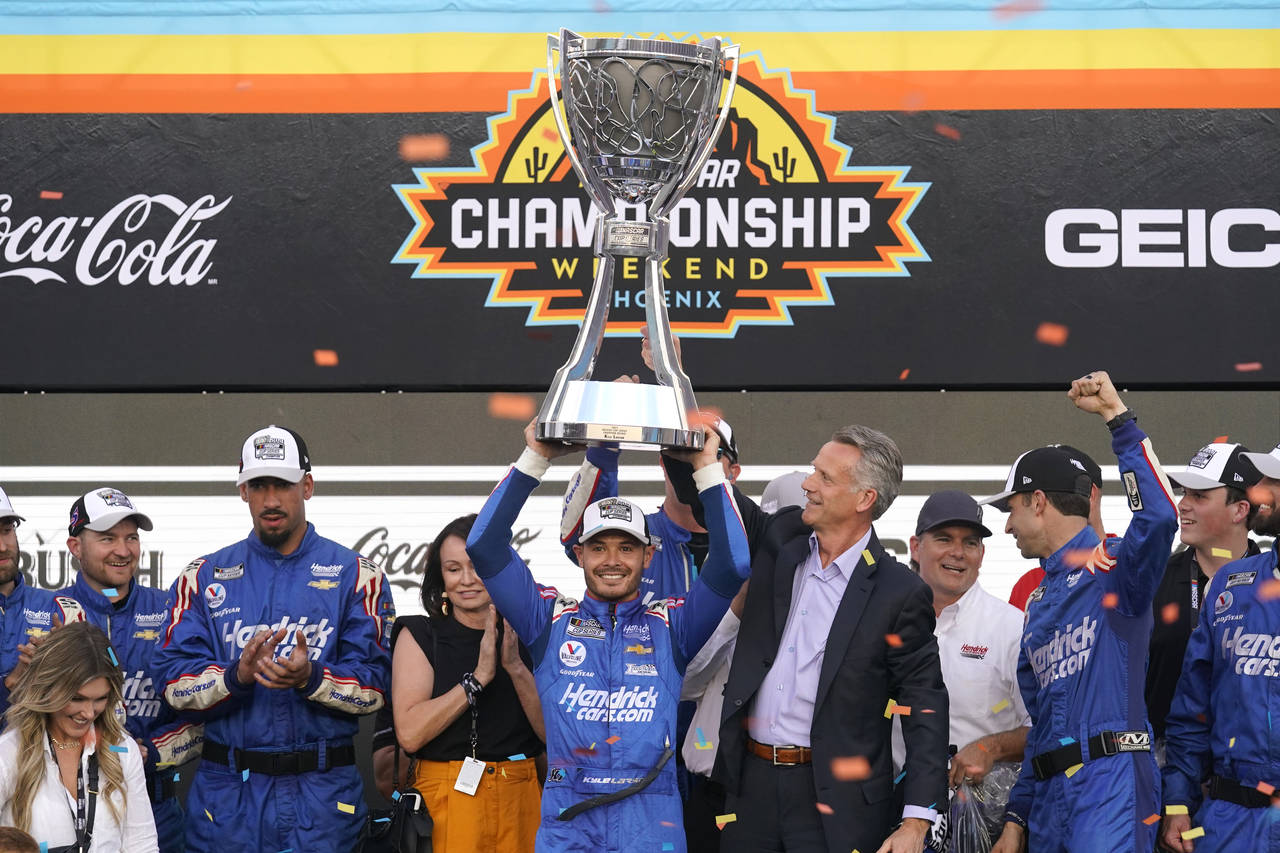Kyle Larson, center, celebrates after winning a NASCAR Cup Series auto race and championship on Sun...