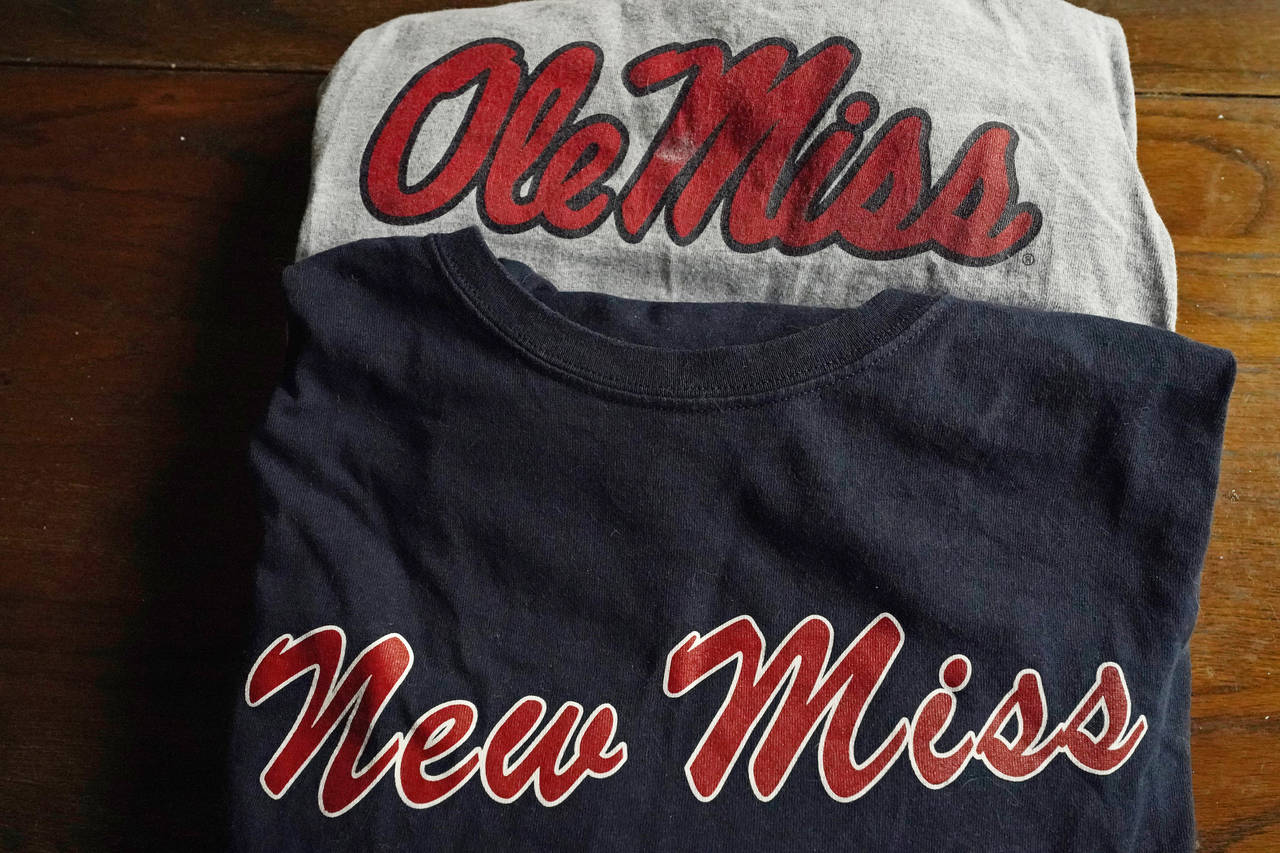 The top t-shirt is emblazoned with one of the University of Mississippi's logos, while the bottom s...