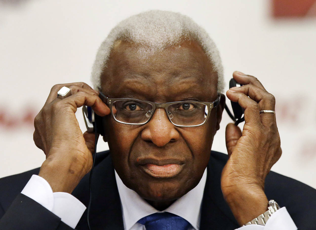 FILE - Lamine Diack adjusts his headphones during a joint IOC and IAAF news conference on the site ...