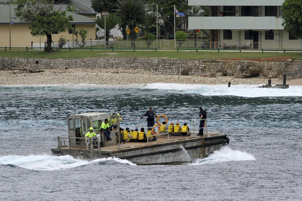 FILE - A group of Vietnamese asylum seekers are taken by barge to a jetty on Australia's Christmas ...
