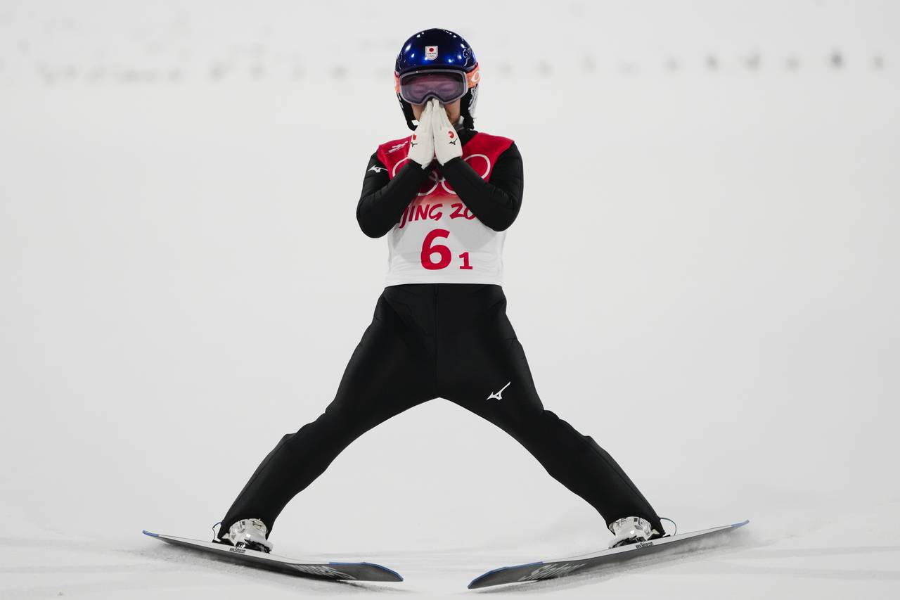 Sara Takanashi, of Japan, reacts after her jump during the ski jumping mixed team final at the 2022...