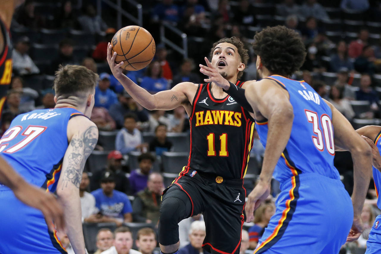 Atlanta Hawks guard Trae Young (11) prepares to shoot as Oklahoma City Thunder guard Vit Krejci, le...