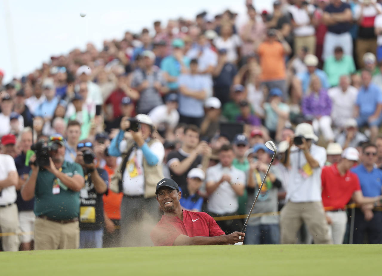 FILE - Tiger Woods plays out of a bunker on the eighth hole during the final round of the British O...