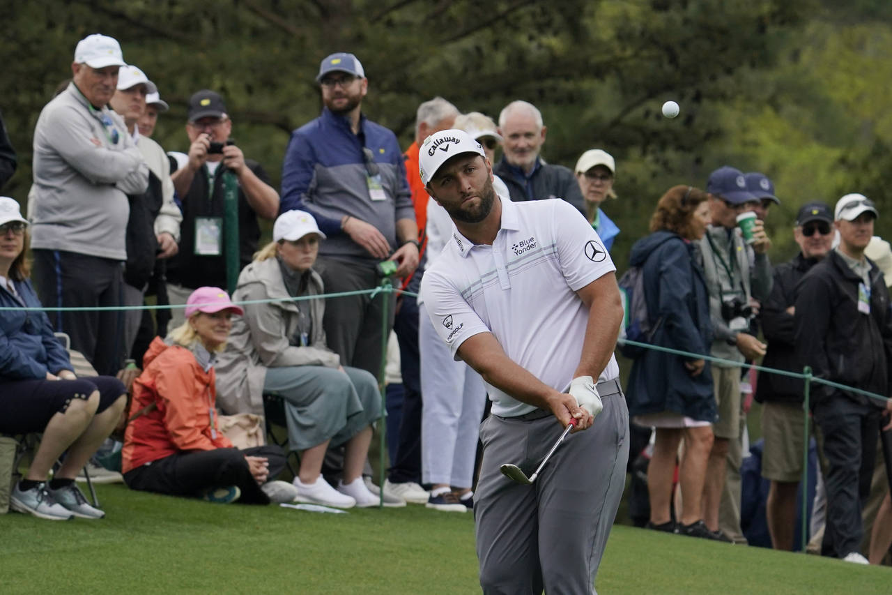 Jon Rahm, of Spain, hits on the 14th hole during a practice round for the Masters golf tournament o...
