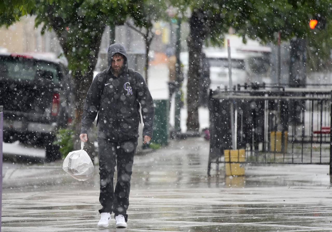 A lone pedestrian moves along 21st Avenue at Market Street as a cold front packing snow, high winds...