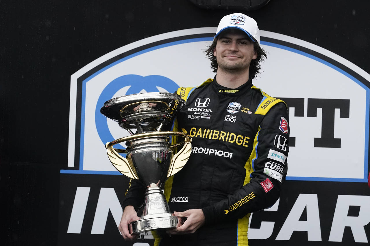 Colton Herta holds the trophy after winning an IndyCar auto race at Indianapolis Motor Speedway, Sa...