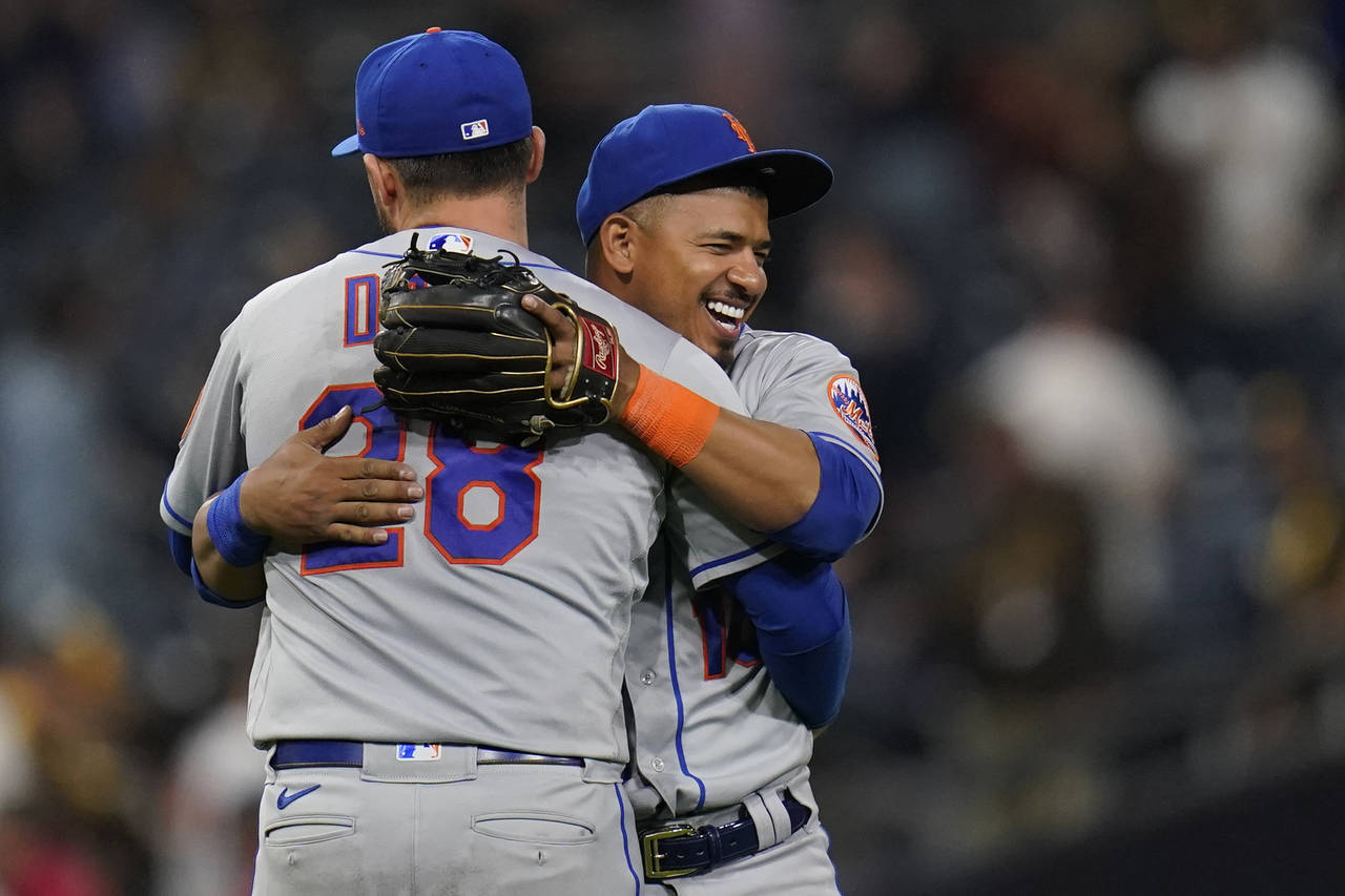 New York Mets third baseman Eduardo Escobar, right, gets a hug from teammate first baseman J.D. Dav...