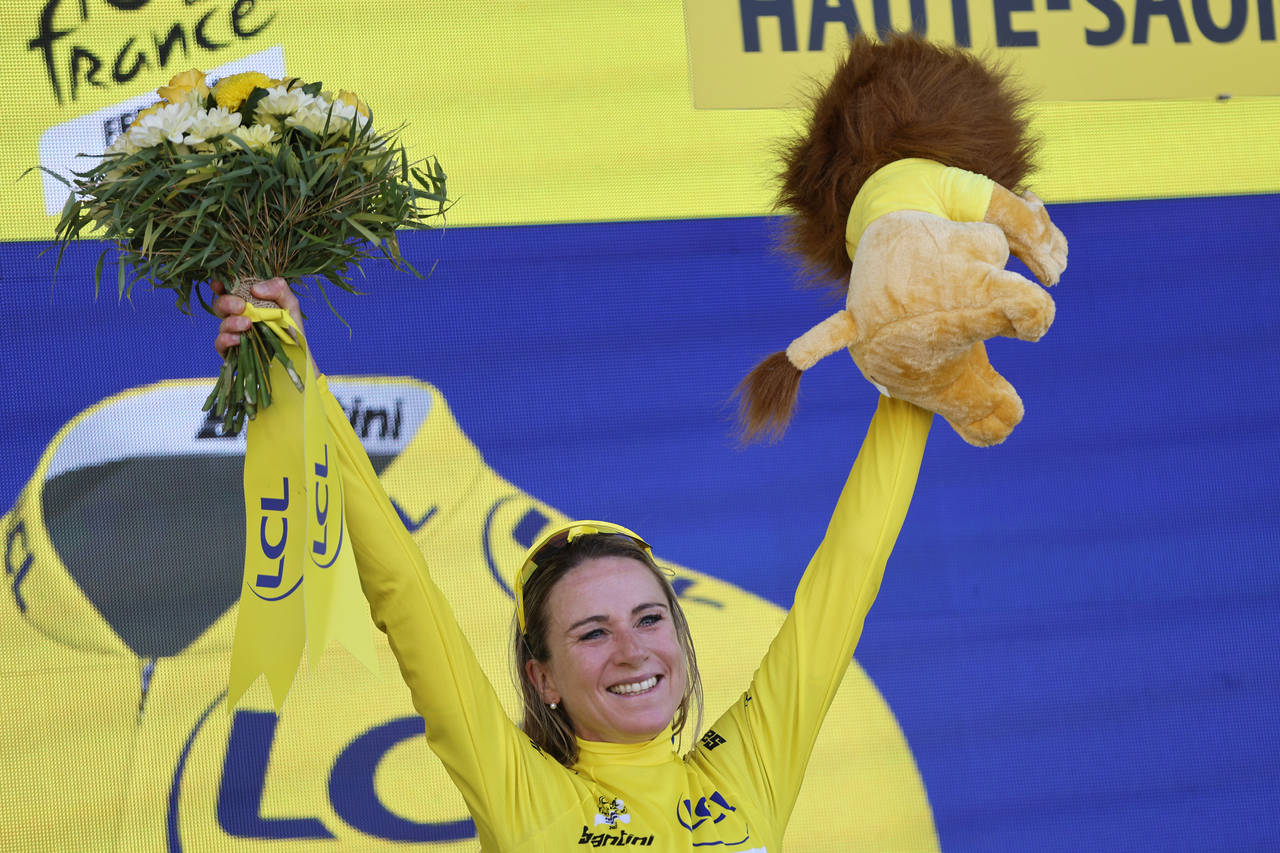 Netherland's Annemiek Van Vleuten, wearing the overall leader's yellow jersey, celebrates on the po...