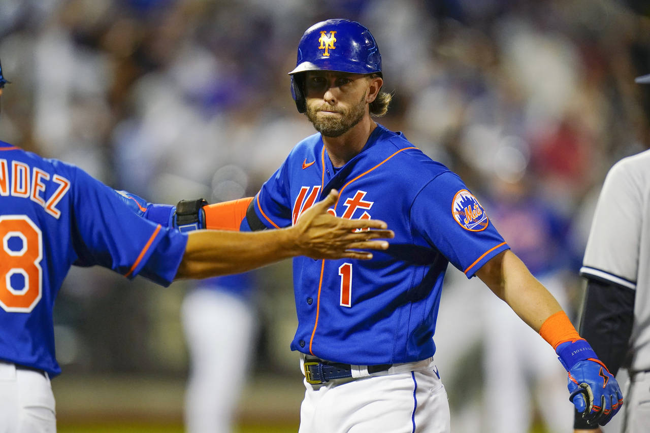 New York Mets' Jeff McNeil (1) celebrates with first base coach Rafael Fernandez after hitting an R...