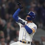 
              Seattle Mariners' Julio Rodriguez gestures after crossing the plate after he hit a solo home run against the Oakland Athletics during the first inning of a baseball game, Sunday, July 3, 2022, in Seattle. (AP Photo/Ted S. Warren)
            