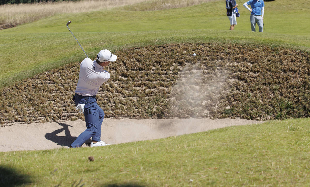 Colin Morikawa from the US plays out of the bunker on the 1st hole during day one of the Scottish O...