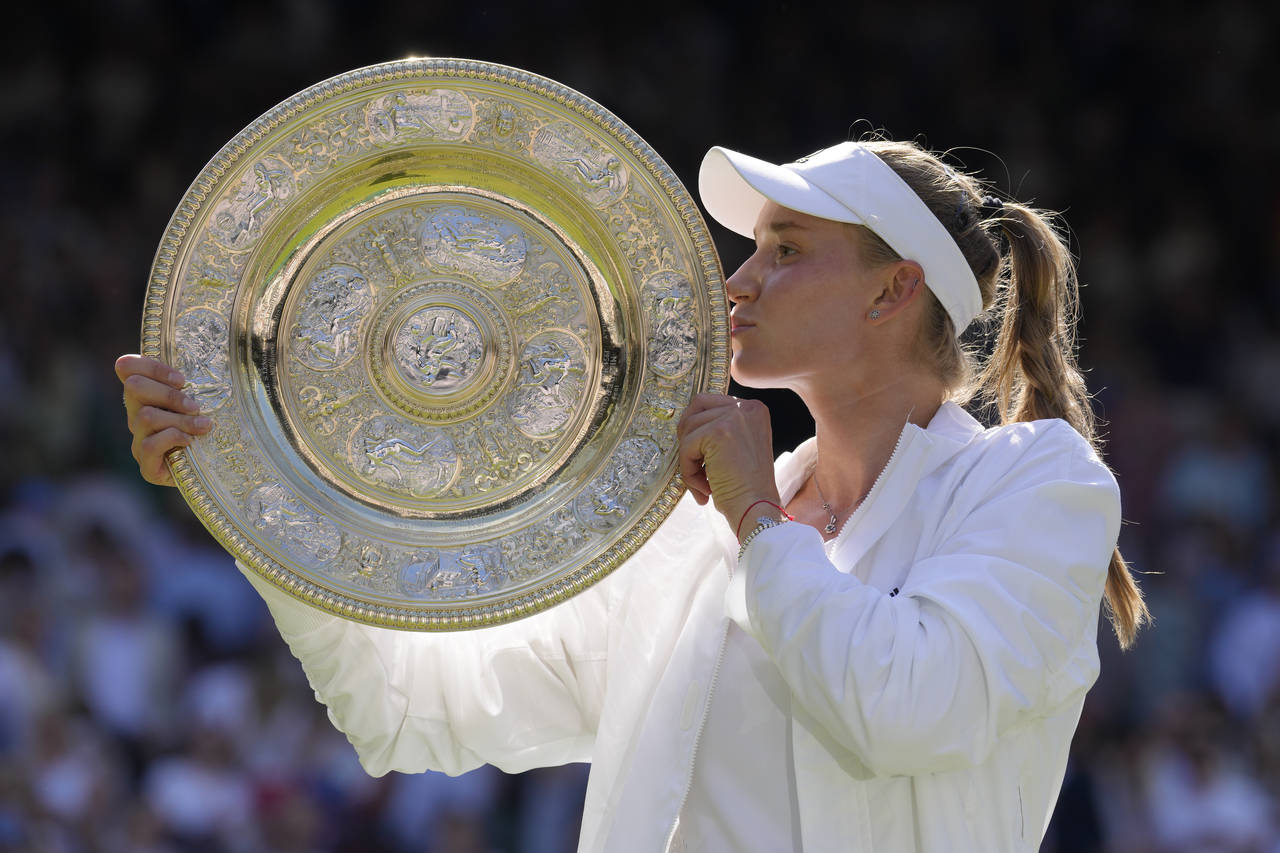 Kazakhstan's Elena Rybakina kisses the trophy as she celebrates after beating Tunisia's Ons Jabeur ...