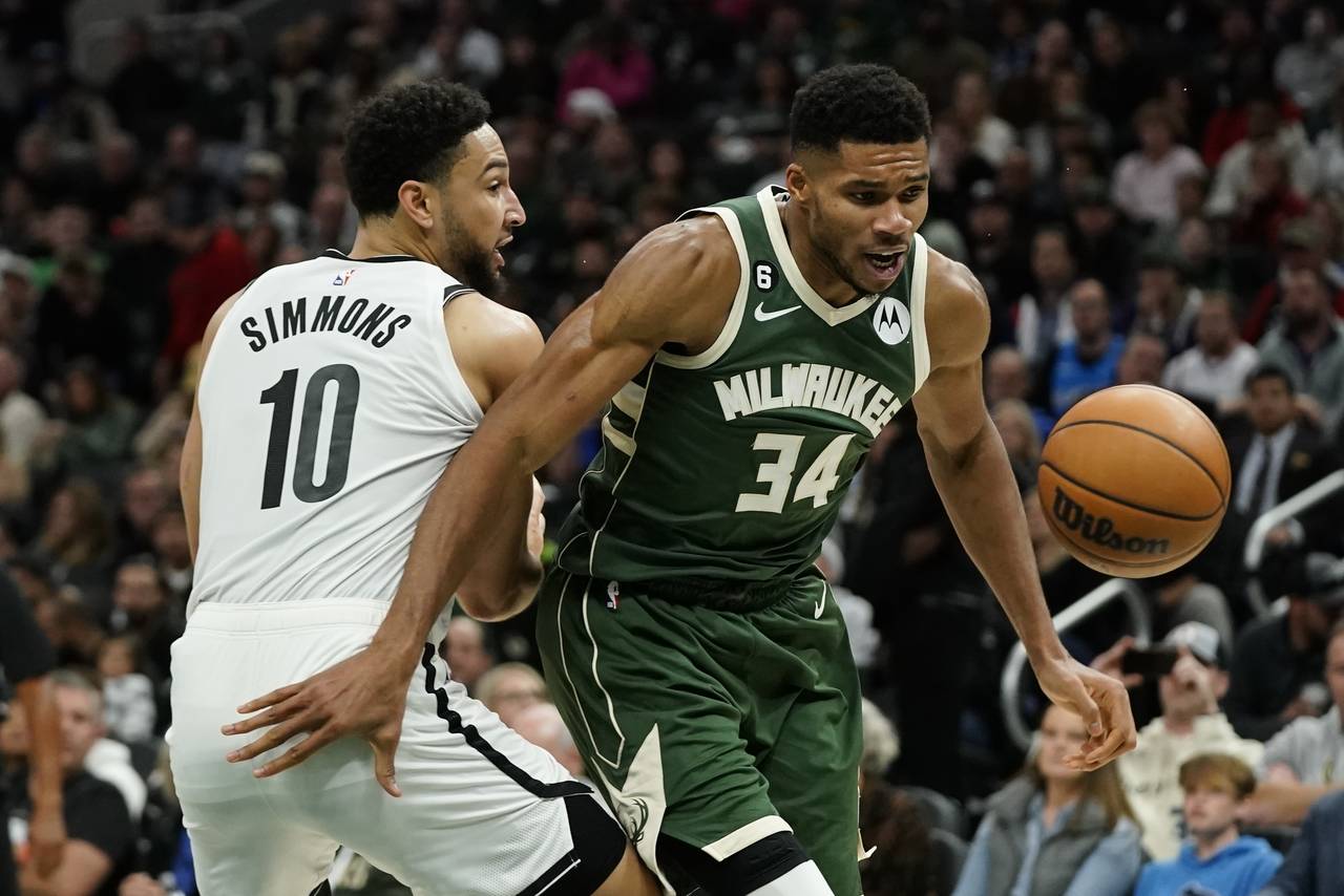 Milwaukee Bucks' Giannis Antetokounmpo (34) and Brooklyn Nets' Ben Simmons (10) go after the ball d...