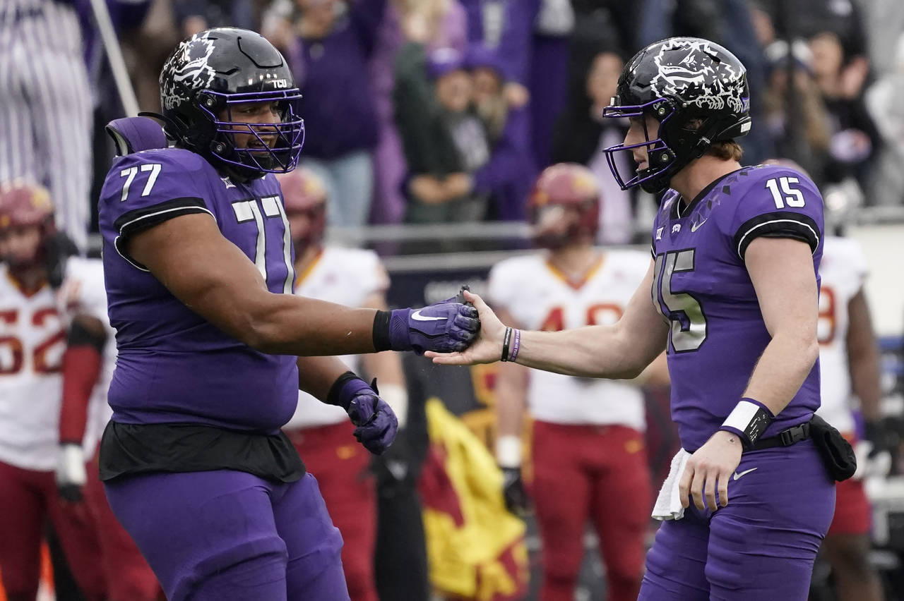 TCU quarterback Max Duggan (15) and offensive tackle Brandon Coleman (77) celebrate a touchdown dur...