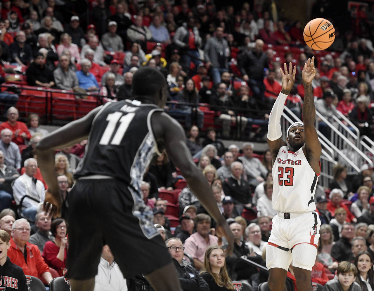 Texas Tech guard De'Vion Harmon (23), right, shoots the ball against Georgetown during an NCAA coll...