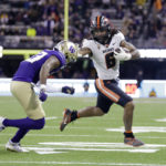 
              Oregon State running back Damien Martinez (6) runs with the ball and pushes off Washington cornerback Mishael Powell (23) during the first half of an NCAA college football game Friday, Nov. 4, 2022, in Seattle. (AP Photo/John Froschauer)
            