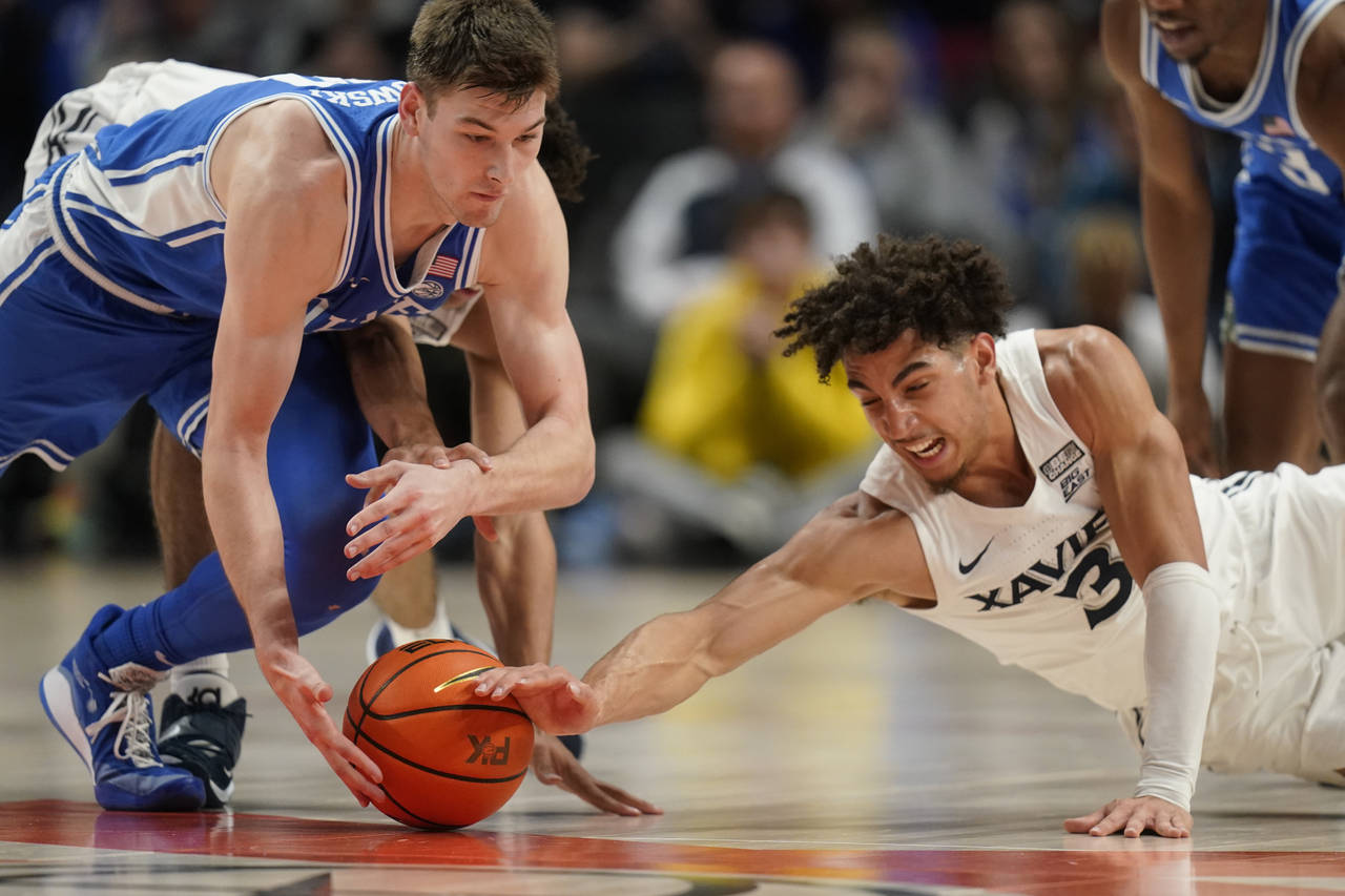 Duke's Kyle Filipowski, left, and Xavier guard Colby Jones (3) battle for the ball during the secon...