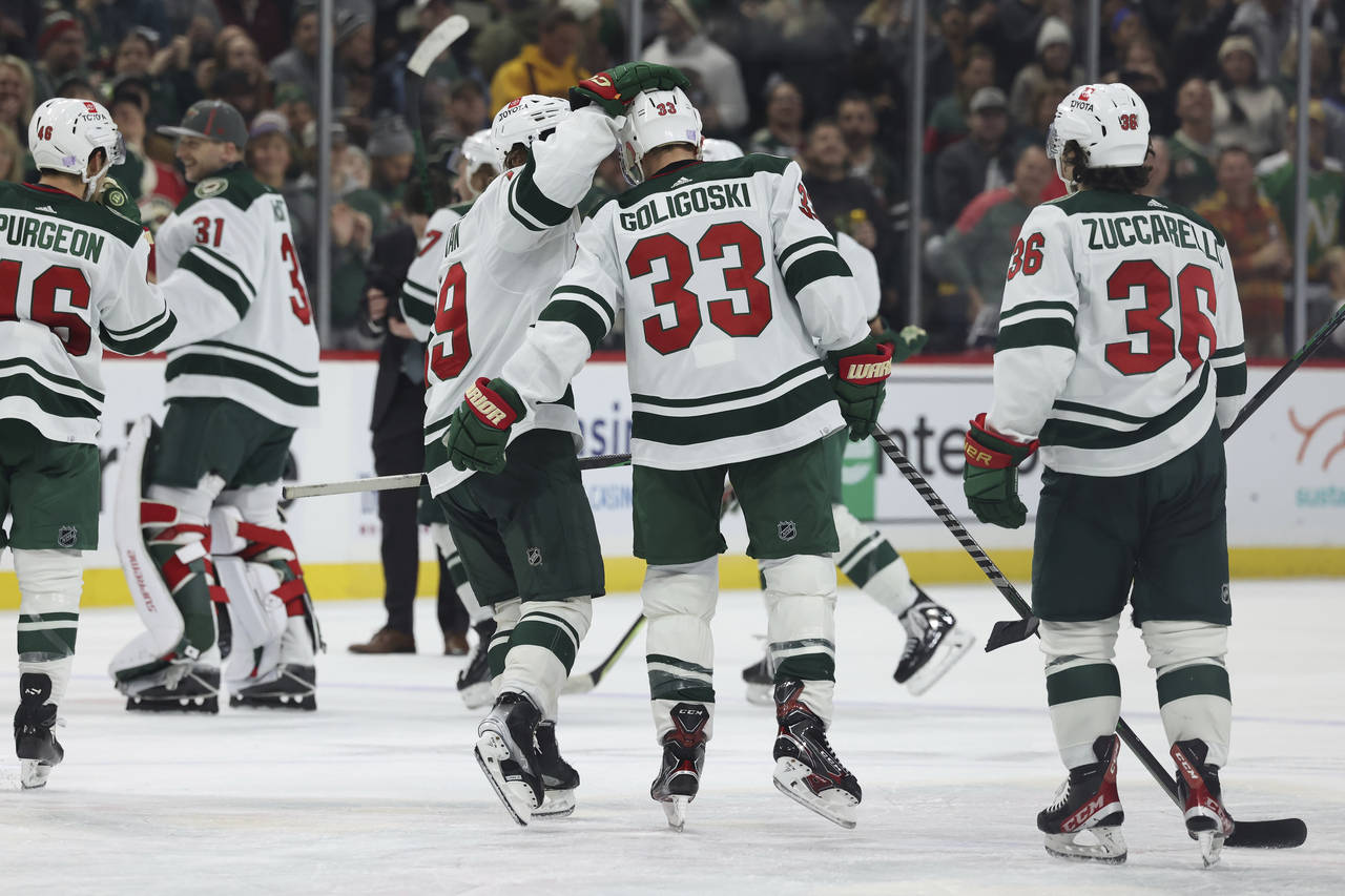 Minnesota Wild defenseman Alex Goligoski (33) celebrates with center Nic Petan (19) after Goligoski...