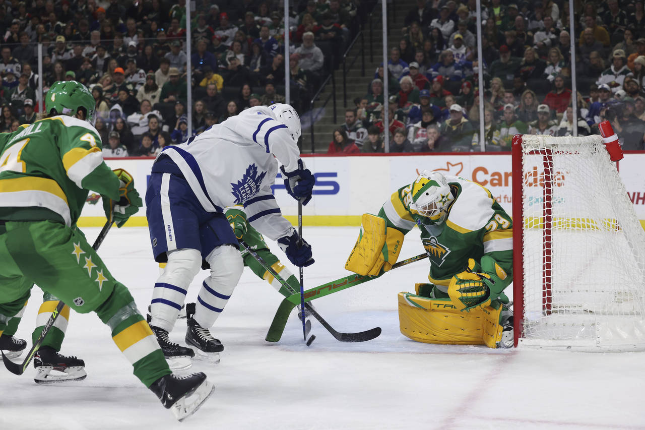 Toronto Maple Leafs center David Kampf (64) tries to score a goal against Minnesota Wild goaltender...