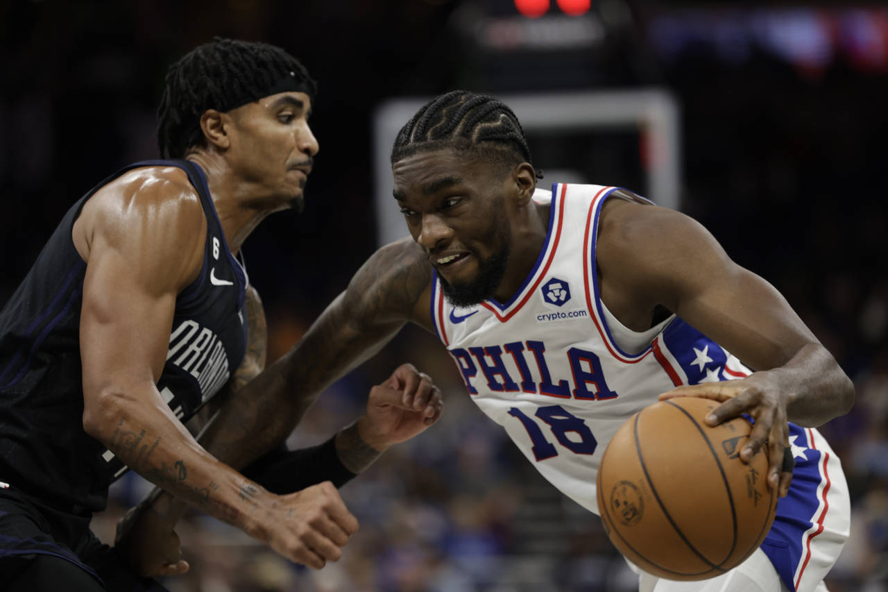 Philadelphia 76ers guard Shake Milton (18) is defended by Orlando Magic guard Gary Harris (14) duri...