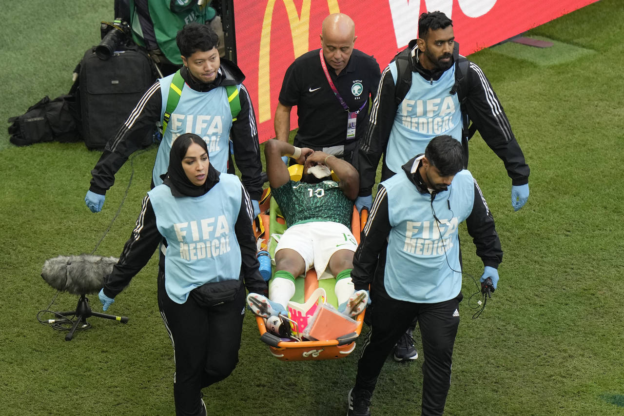 Paramedics carry Saudi Arabia's Yasser Al-Shahrani on a stretcher during the World Cup group C socc...