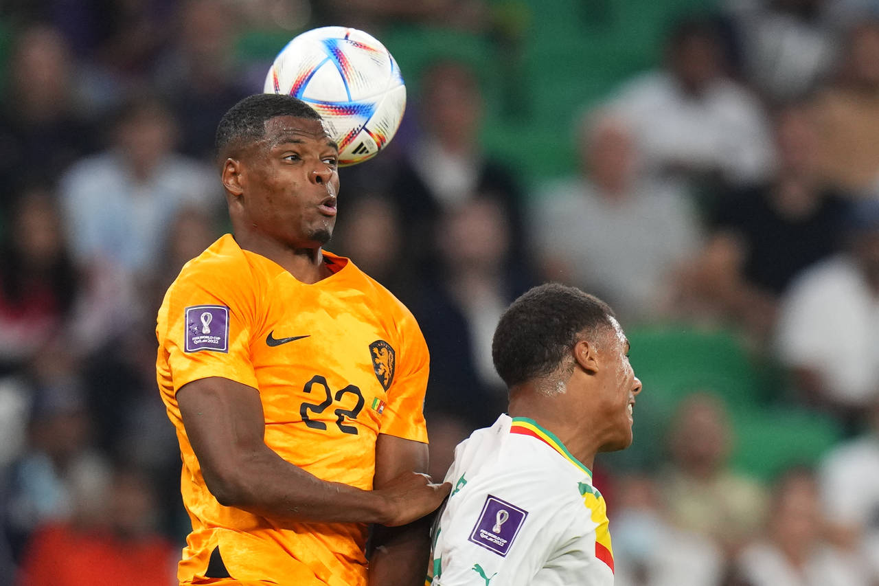 Denzel Dumfries of the Netherlands and Senegal's Formose Mendy go for a header during the World Cup...