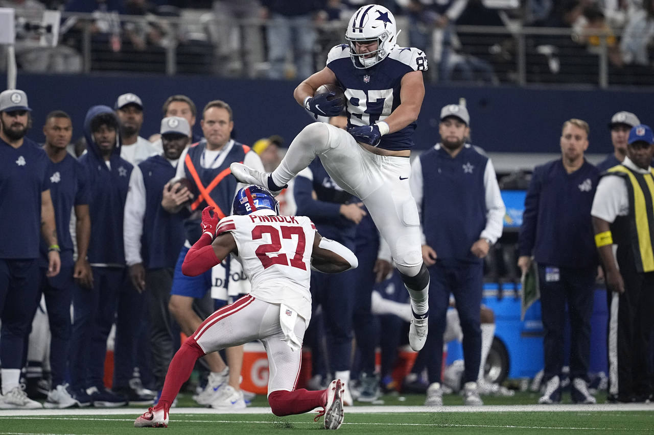 Dallas Cowboys tight end Jake Ferguson (87) leaps over New York Giants cornerback Jason Pinnock (27...