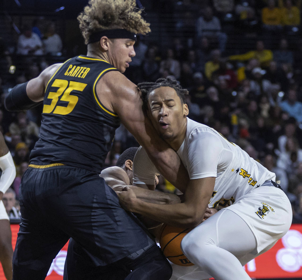 Wichita State's Shaman Scott, right, has the ball as Missouri's Nick Honor, middle, and Noah Carter...