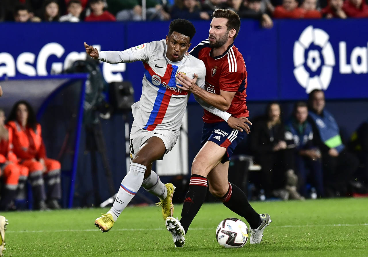 Barcelona's Alejandro Balde, left, challenges for the ball with Osasuna's Jon Moncayola during a Sp...