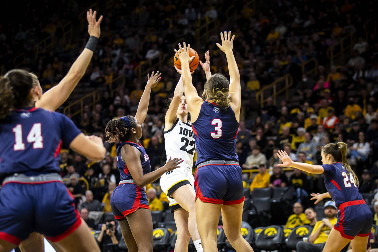 Iowa guard Caitlin Clark (22) shoots a basket as Belmont guard Tuti Jones and Belmont forward Madis...