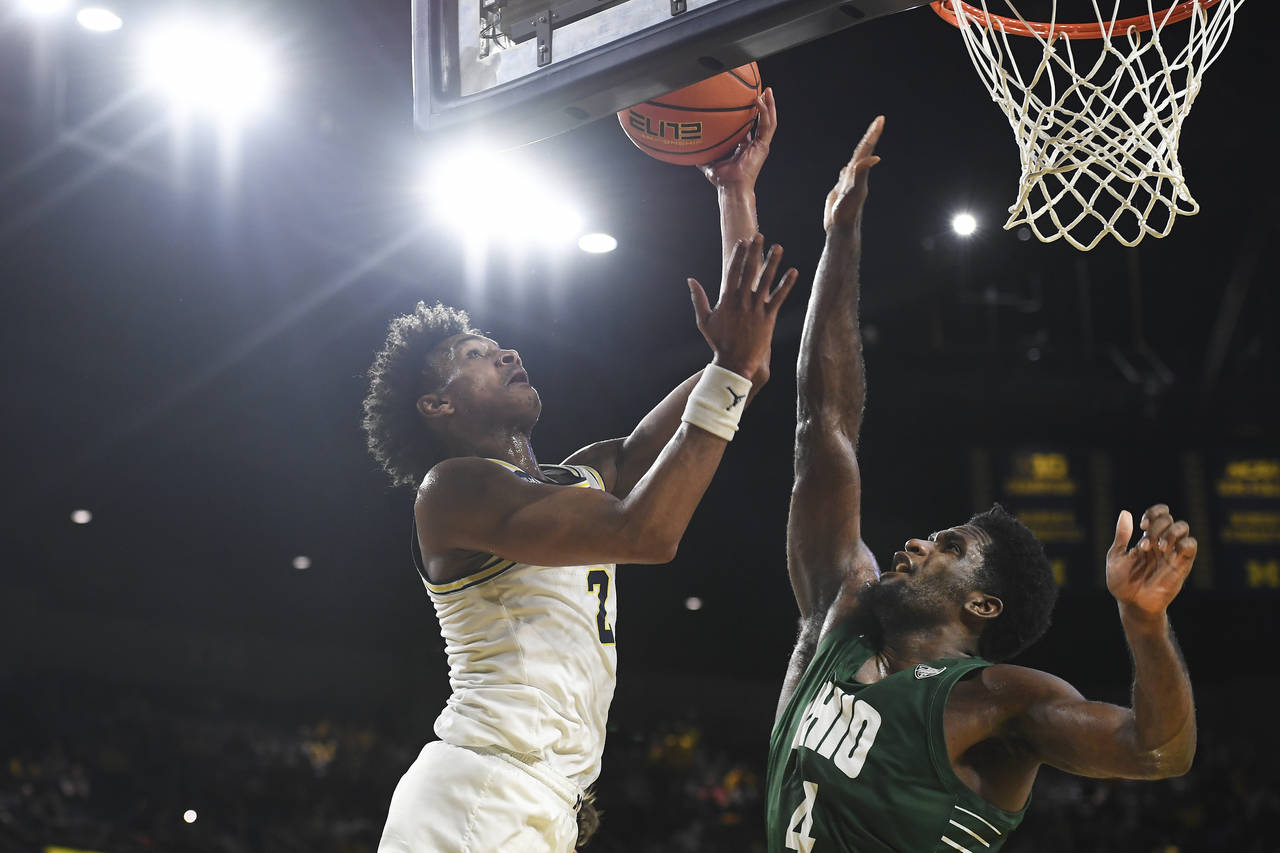 Michigan guard Kobe Bufkin, left, drives to the basket against Ohio forward Dwight Wilson III in ov...