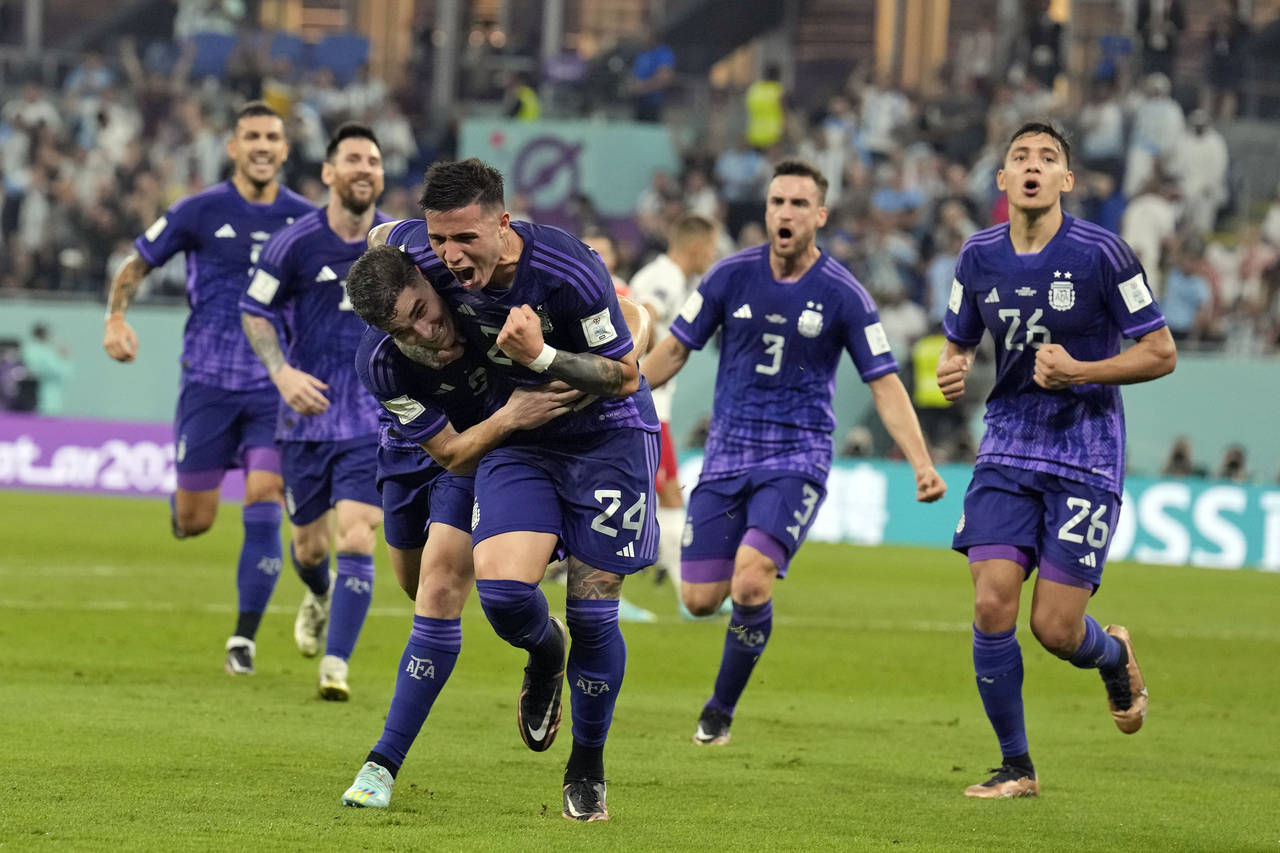 Argentina's Julian Alvarez, front left, is embraced by teammate Enzo Fernandez (24) after scoring a...