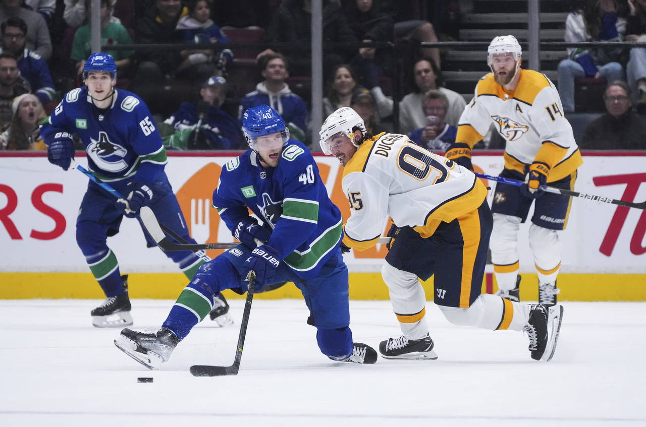 Vancouver Canucks' Elias Pettersson (40) and Nashville Predators' Matt Duchene (95) vie for the puc...