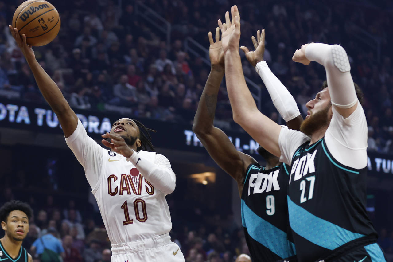 Cleveland Cavaliers guard Darius Garland (10) shoots as Portland Trail Blazers center Jusuf Nurkic ...