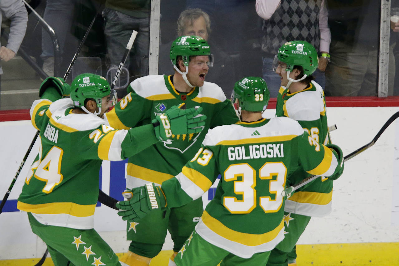 Minnesota Wild center Mason Shaw celebrates after scoring a goal with teammates Matt Dum), Alex Gol...