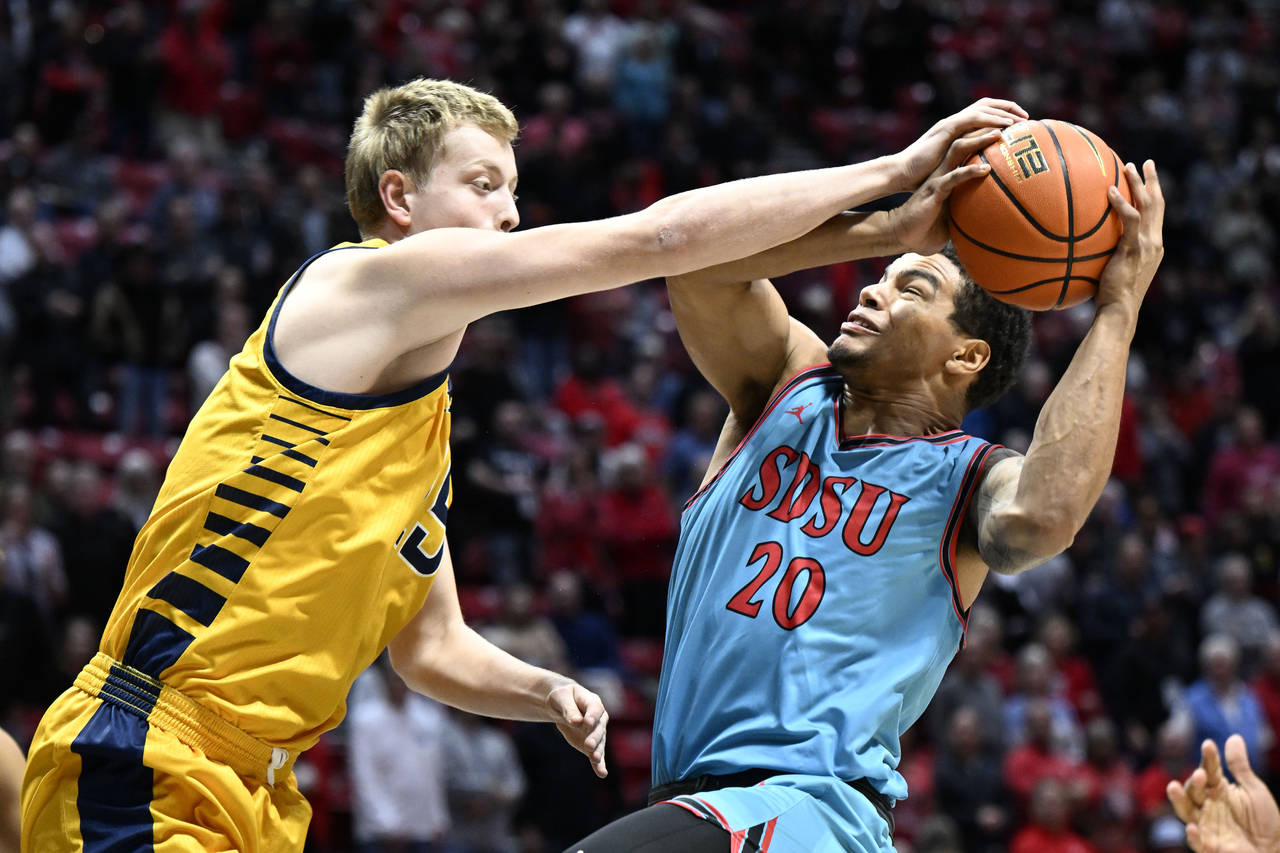 San Diego State guard Matt Bradley (20) is fouled by UC Irvine center Bent Leuchten (15) during the...