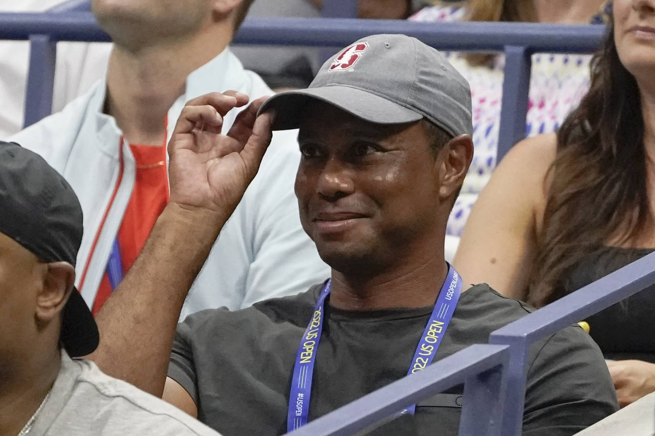 FILE - Tiger Woods tips his hat to the crowd during a match between Serena Williams and Anett Konta...