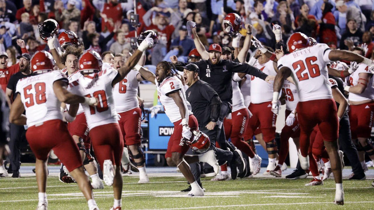 North Carolina State players and coaches celebrate after North Carolina missed a field-goal attempt...