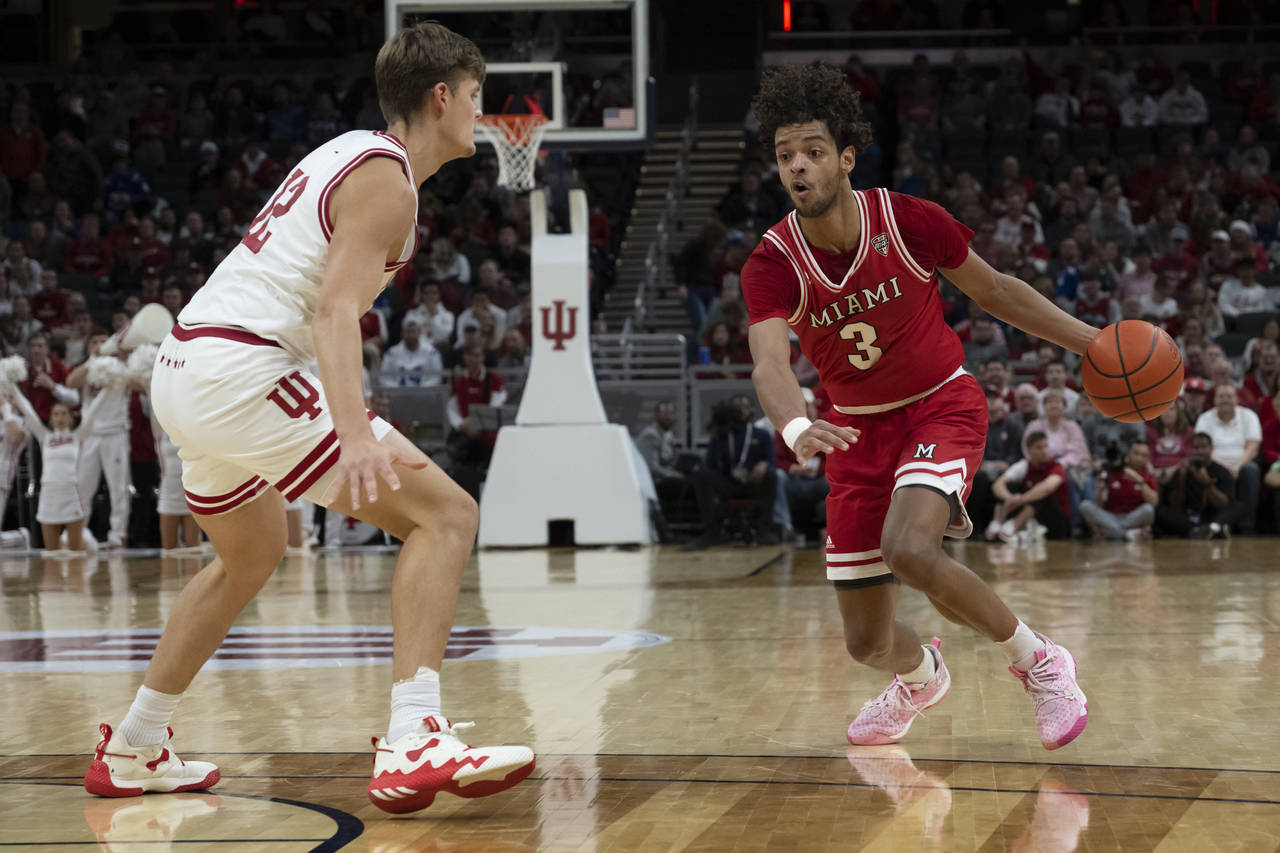 Miami (Ohio) guard Julian Lewis (3) dribbles around Indiana forward Miller Kopp (12) during the fir...